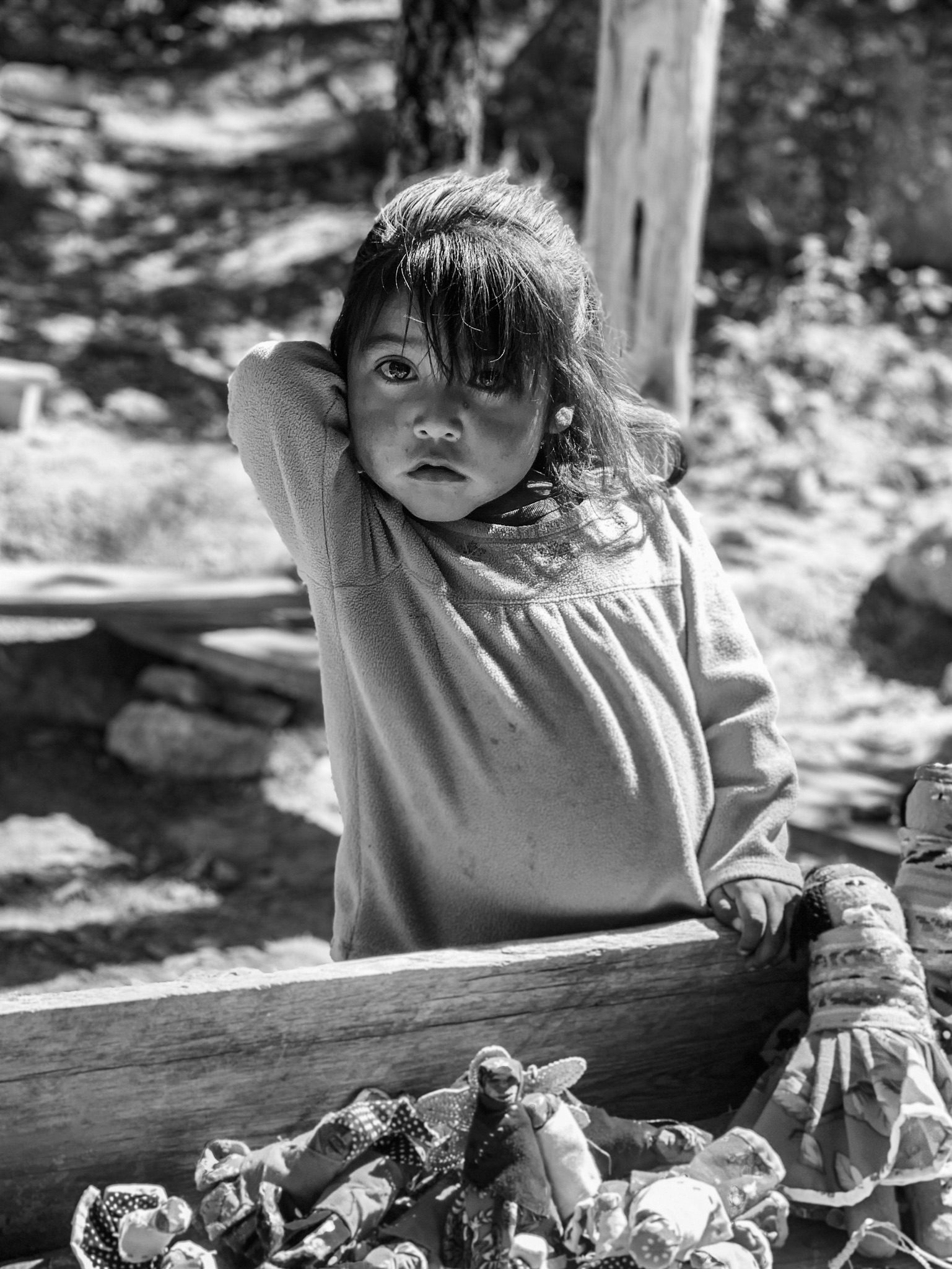 Blanco y negro, niña recargada en madera